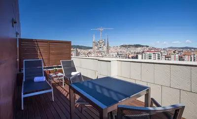 a blue table and chairs on a balcony with a view at Eurostars Monumental in Barcelona