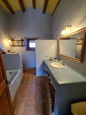 a bathroom with a sink and a tub and a mirror at Cal Colina - Karaktervol landhuis met privé zwembad in Pacs del Penedes
