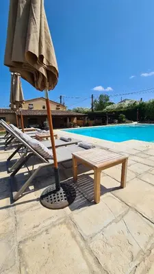 a umbrella and a paddle next to a chair and a pool at Cal Colina - Karaktervol landhuis met privé zwembad in Pacs del Penedes
