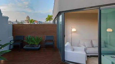 a balcony with a white couch and a chair at Cram Hotel in Barcelona