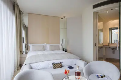 a bedroom with a large bed and two chairs at Cram Hotel in Barcelona