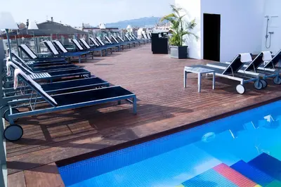 a row of lounge chairs next to a swimming pool at Axel Hotel Barcelona - Adults Only in Barcelona