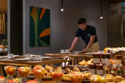 a man standing in front of a buffet of food at Axel Hotel Barcelona - Adults Only in Barcelona