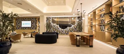 a lobby with a waiting area with chairs and tables at Ilunion Les Corts Spa in Barcelona