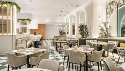a restaurant with tables and chairs in a room at Ilunion Les Corts Spa in Barcelona