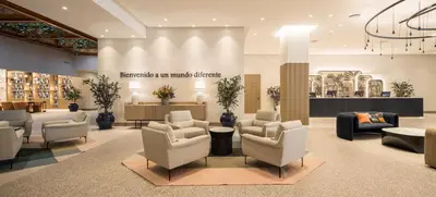a waiting area with chairs and tables in a building at Ilunion Les Corts Spa in Barcelona