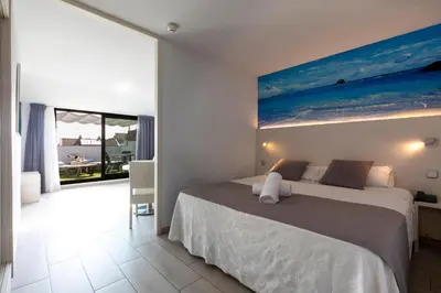 a bedroom with a bed and a painting on the wall at Aparthotel Miami Park in Calella
