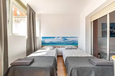 two beds in a room with a view of the ocean at Dream House in Badalona