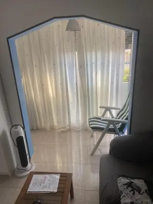a view of a living room with a chair and a mirror at 3 BDRM APART NEAR THE SEA! GREAT FOR KIDS! in Arenys de Mar