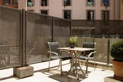 a table and chairs on a balcony with a fence at Casa Elliot Hotel in Barcelona