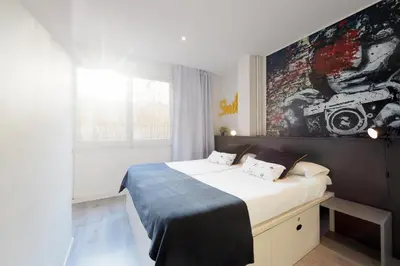 a bedroom with a bed with a painting on the wall at Free Hostels Barcelona in Barcelona