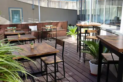 a restaurant with wooden tables and chairs and plants at Eurohotel Barcelona Granvia Fira in Hospitalet de Llobregat