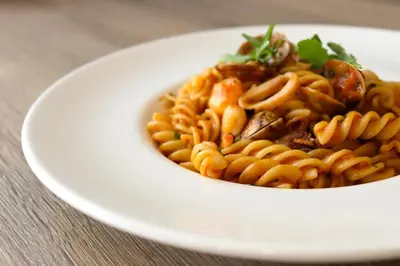 a white bowl of pasta on a white plate at Eurohotel Barcelona Granvia Fira in Hospitalet de Llobregat