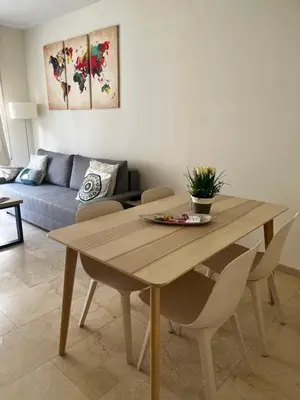 a wooden table in a living room with a couch at Precioso y tranquilo apartamento zona alta Diagonal Barcelona in Barcelona