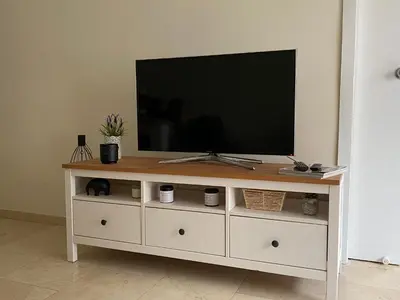 a television sitting on top of a white entertainment center at Precioso y tranquilo apartamento zona alta Diagonal Barcelona in Barcelona