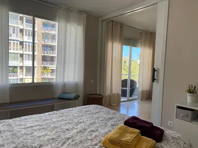 a bedroom with a bed and a large window at Precioso y tranquilo apartamento zona alta Diagonal Barcelona in Barcelona