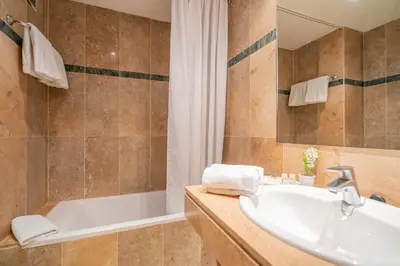 a bathroom with a tub and a sink at Hotel Glòries in Barcelona