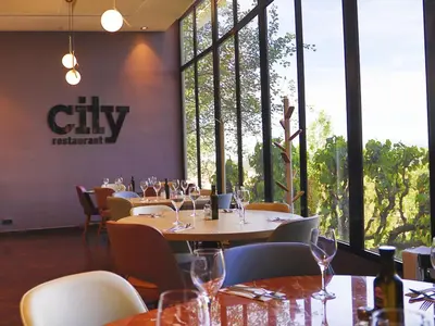 a dining room with tables and chairs and windows at Ciutat de Granollers in Granollers