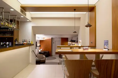 a bar with a counter and chairs in a room at Best Western Premier Hotel Dante in Barcelona