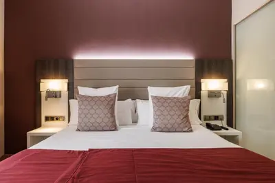 a bedroom with a large bed with two lamps at Hotel Ronda Lesseps in Barcelona