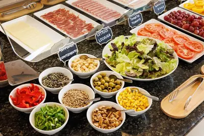 a counter topped with bowls of different types of food at Hotel Ronda Lesseps in Barcelona