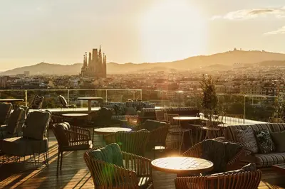 a restaurant with tables and chairs and a view of a city at The Hoxton, Poblenou in Barcelona