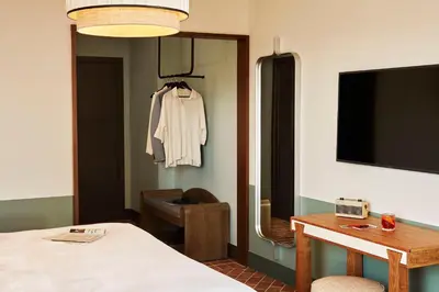 a room with a bed and a table and a tv at The Hoxton, Poblenou in Barcelona