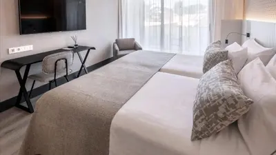 a hotel room with a large bed with a desk at Bel Air in Castelldefels
