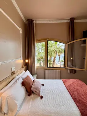 a bedroom with a large bed with a window at Hotel Celimar in Sitges