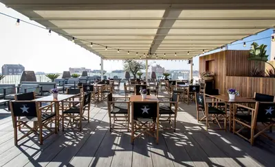 a patio with tables and chairs on a roof at Hotel Urpí in Sabadell