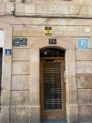 a stone building with a door with a metal gate at Pensión Bertolín in Barcelona