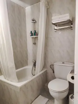 a bathroom with a toilet and a tub and a sink at Pensión Bertolín in Barcelona