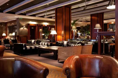 a lobby with couches and a table and chairs at Hotel 1898 in Barcelona
