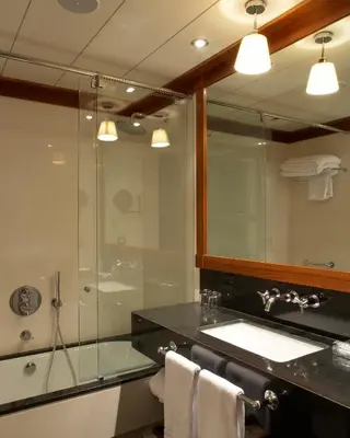 a bathroom with a shower and a sink and a mirror at Hotel 1898 in Barcelona
