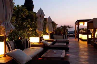 a patio with couches and umbrellas on a deck at Hotel 1898 in Barcelona