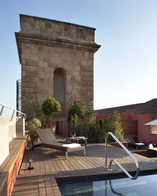 a backyard with a swimming pool and a wooden deck at Hotel 1898 in Barcelona