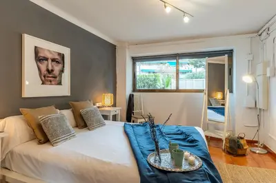 a bedroom with a large white bed with blue sheets at Canela Homes COSTA CA NOSTRA in Gavà