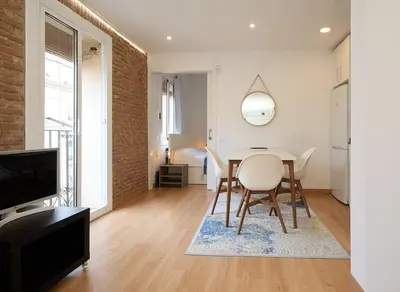a living room with a table and chairs and a television at GuestReady - Acogedor Apt en La Barceloneta in Barcelona