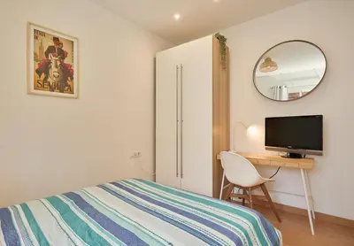 a bedroom with a bed and a desk with a television at GuestReady - Acogedor Apt en La Barceloneta in Barcelona