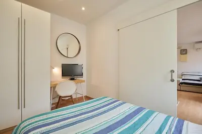 a bedroom with a bed and a desk with a television at GuestReady - Acogedor Apt en La Barceloneta in Barcelona