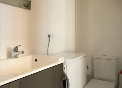a white bathroom with a sink and a toilet at GuestReady - Acogedor Apt en La Barceloneta in Barcelona