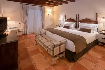 a large bedroom with a large bed and a television at Gran Hotel Rey Don Jaime in Castelldefels