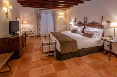 a hotel room with a large bed and a television at Gran Hotel Rey Don Jaime in Castelldefels