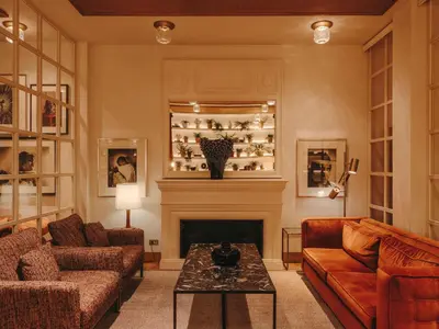 a living room with a couch and a fireplace at Hotel Pulitzer Barcelona in Barcelona