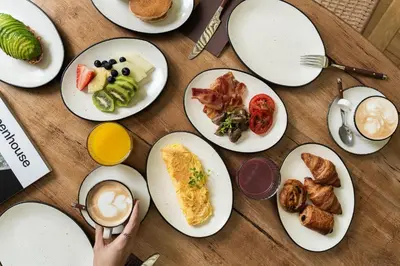 a table with plates of breakfast food on it at Hotel Pulitzer Barcelona in Barcelona