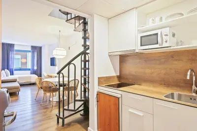 a kitchen and living room with a spiral staircase in a apartment at Hotel Acta Azul Barcelona in Barcelona