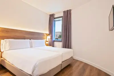 a bedroom with a large white bed with a window at Hotel Acta Azul Barcelona in Barcelona