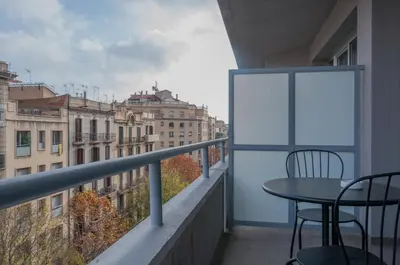 a balcony with a table and chairs and buildings at Aparthotel Atenea Calabria in Barcelona