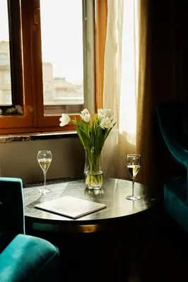 a table with a vase of flowers and two glasses at El Avenida Palace in Barcelona