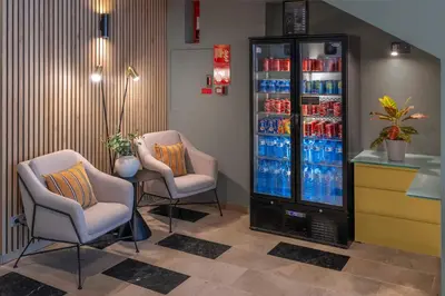a soda machine in a store with two chairs at Hotel SERHS Del Port in Barcelona